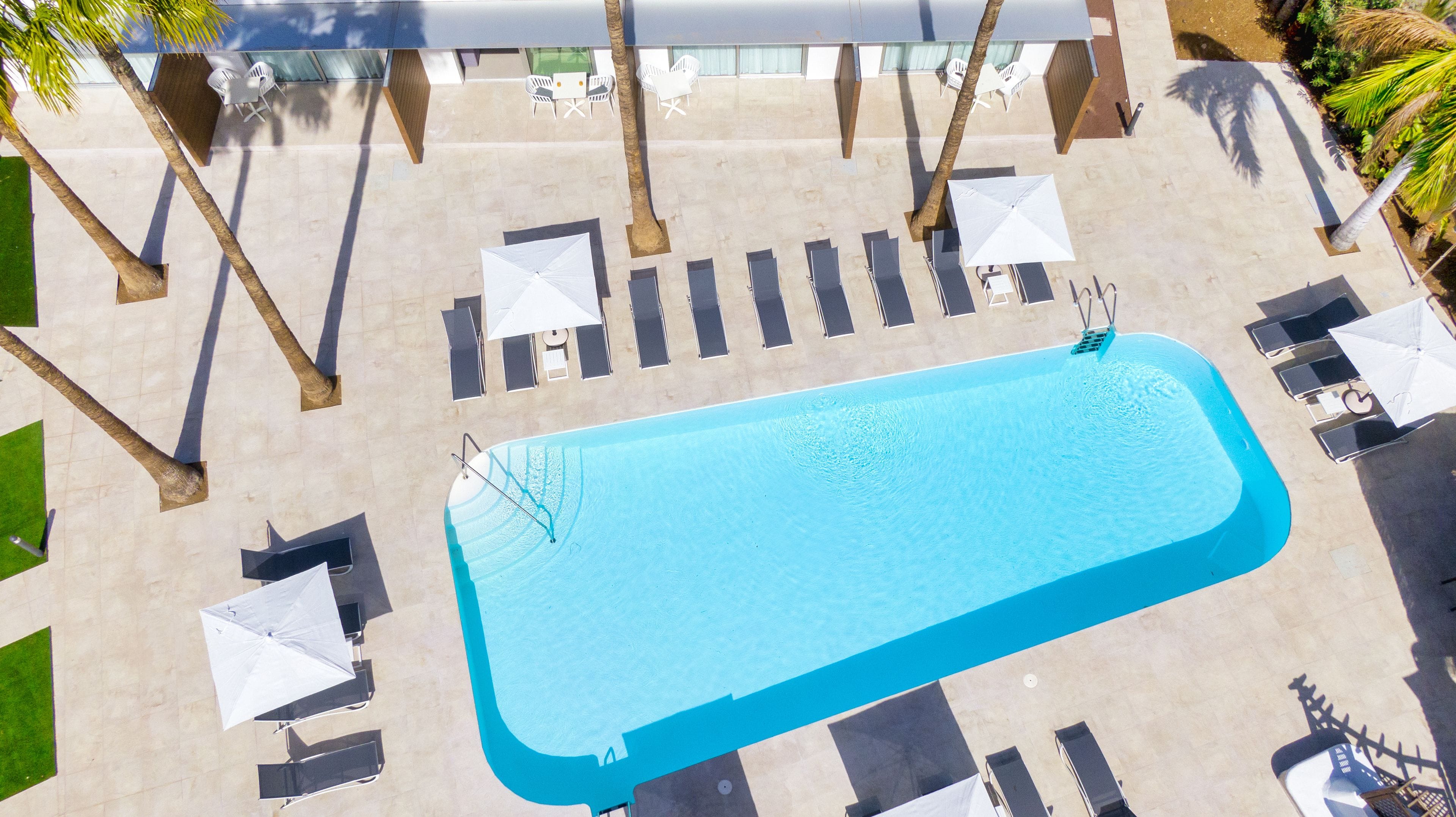 Een buitenzwembad, parasols voor strand/zwembad