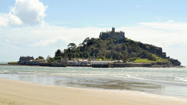Um castelo à beira-mar numa colina com vista para o mar.