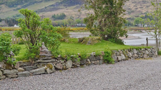 A stone wall with a grassy area and a river in the background. - 2 bedroom accommodation in Glenelg, near Kyle of Lochalsh (Glenelg, near Kyle of Lochalsh)