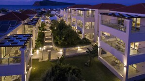 A multi-story hotel with outdoor seating areas and a well-lit courtyard. - Isida Hotel (Chania)