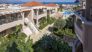 A resort with multiple buildings, a swimming pool, and a view of the sea. - Isida Hotel (Chania)
