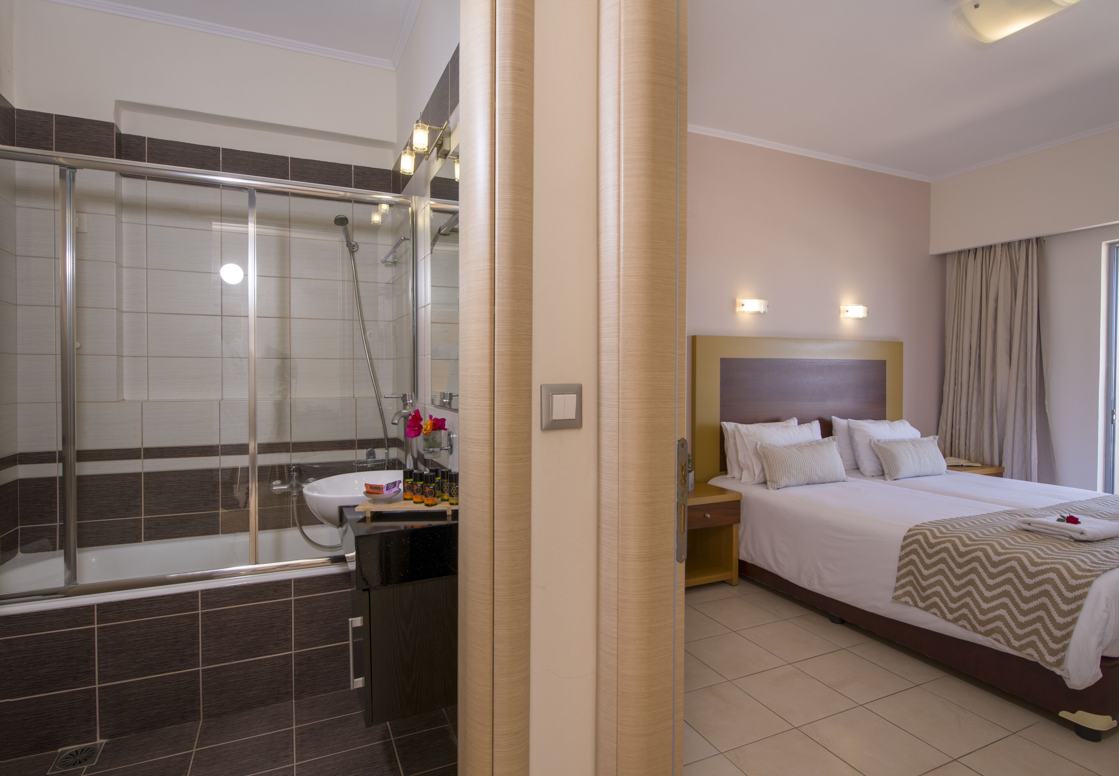 Une chambre d’hôtel équipée d’une douche, d’un lit, d’une table de chevet et d’une petite table à côté du lit.