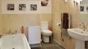 A modern bathroom with a bathtub, toilet, and sink. - 2 bedroom accommodation in Tynlon, near Rhosneigr (Tynlon, near Rhosneigr)