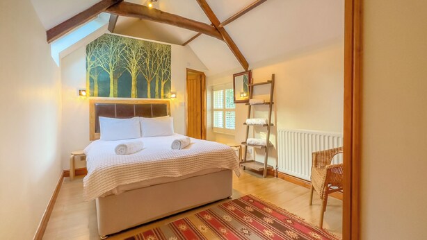 A bedroom with a bed, a painting, a ladder, and a chair. - Old Hall Cottage No 1 (Byers Green, near Durham)
