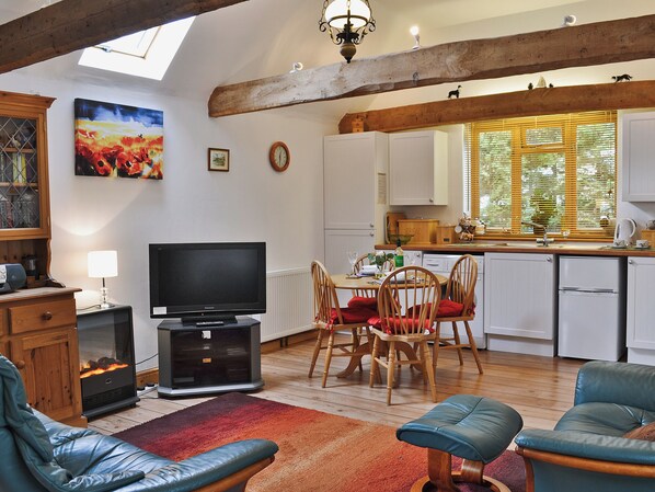 Una sala de estar acogedora con chimenea, televisor y asientos cómodos.