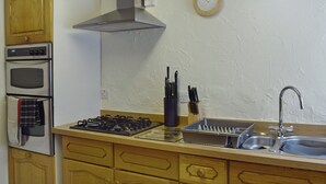 A compact kitchen with a stove, oven, and sink. - Hayrake is in an ideal location, on the fringes of Ambleside. (Ambleside)