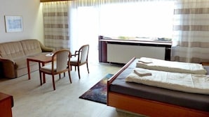 A hotel room with a bed, a sofa, a desk, and a chair. - Hotel Garni Sebastian (Kirrweiler)