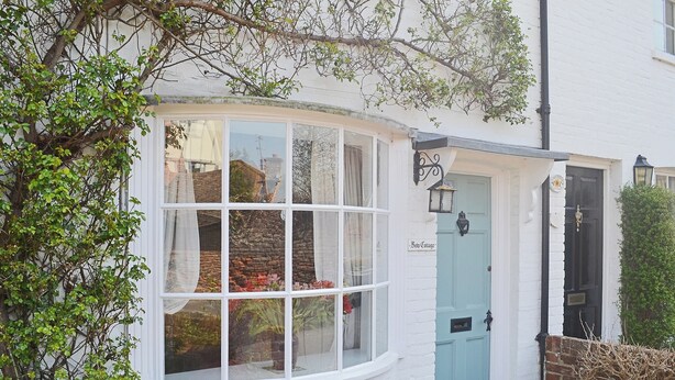 Un bâtiment blanc avec une porte bleue et une baie vitrée.