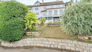A two-story house with a stone wall in the foreground. - 6 bedroom accommodation in St Margarets Bay, Dover (St Margarets Bay, Dover)