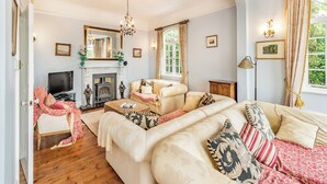 A living room with a fireplace, sofas, and a television. - 6 bedroom accommodation in St Margarets Bay, Dover (St Margarets Bay, Dover)