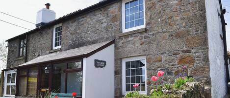 A stone building with a sign reading "Trecarne Cottage."