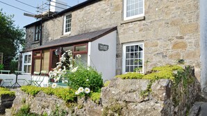 A stone cottage with a sign reading "Trearne Cottage."