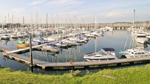 Een jachthaven met veel boten afgemeerd aan houten steigers.