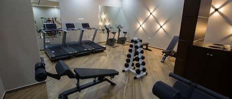 A gym with treadmills, stationary bikes, and free weights.