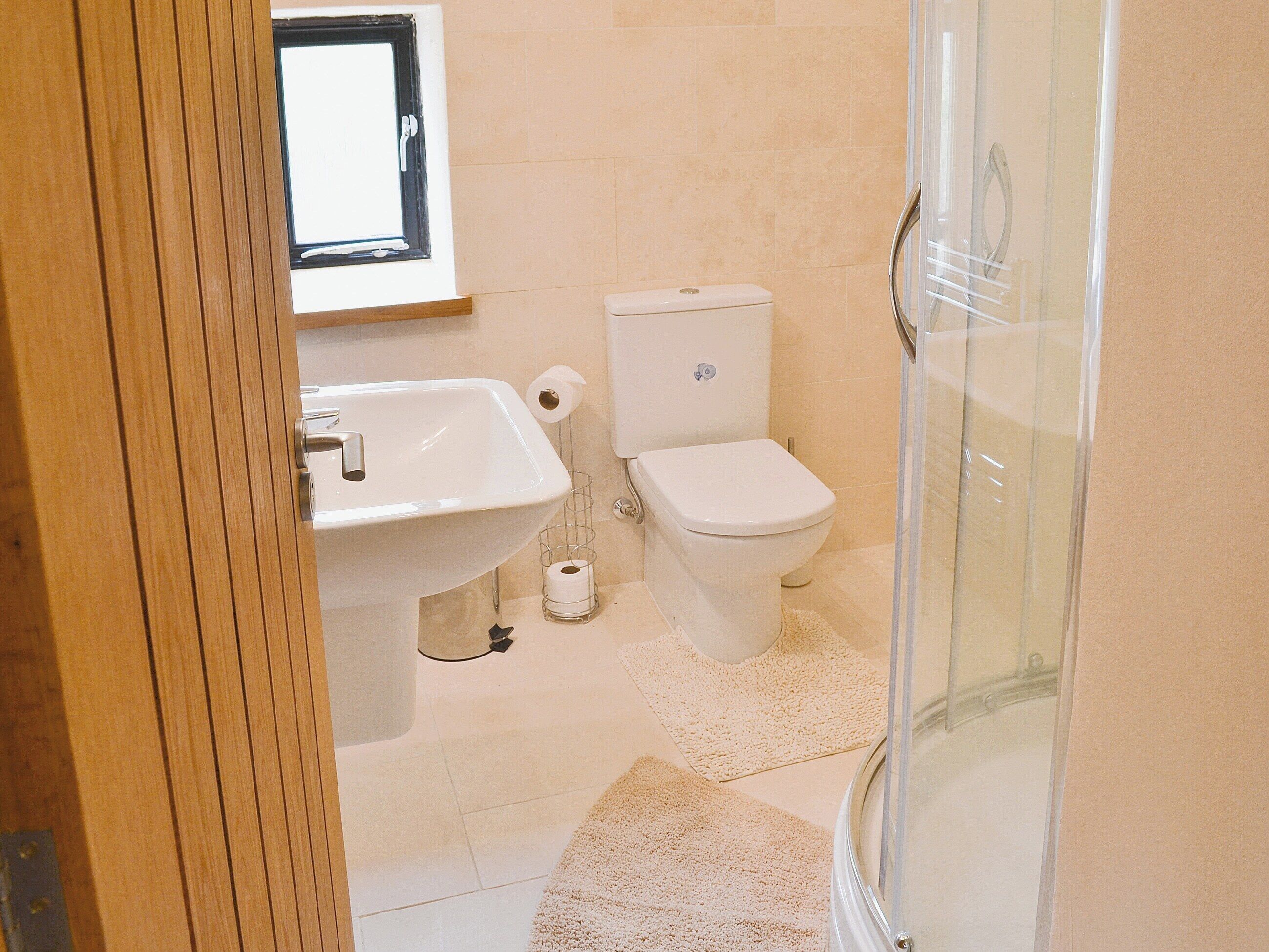 A bathroom with a sink, toilet, and glass shower stall.