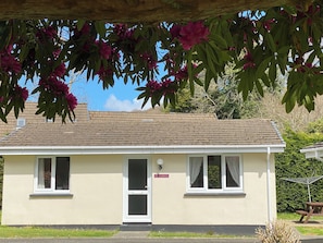 A single-story building with a flat roof, a door, and two windows.