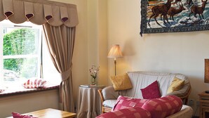 A cozy living room with a sofa, a table, and a lamp. - 2 bedroom accommodation in Portree (Portree)