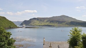A calm lake with boats, green hills, and a clear sky. - 2 bedroom accommodation in Portree (Portree)