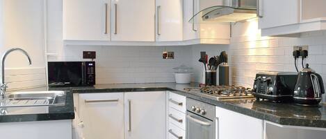 Een vaatwasser, een kinderstoel, kookgerei, borden en bestek