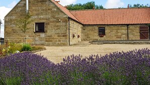 A stone building with a red-tiled roof, two windows, and a small garden with lavender. - 3 bedroom accommodation in Westerdale, near Castleton (Westerdale, near Castleton)