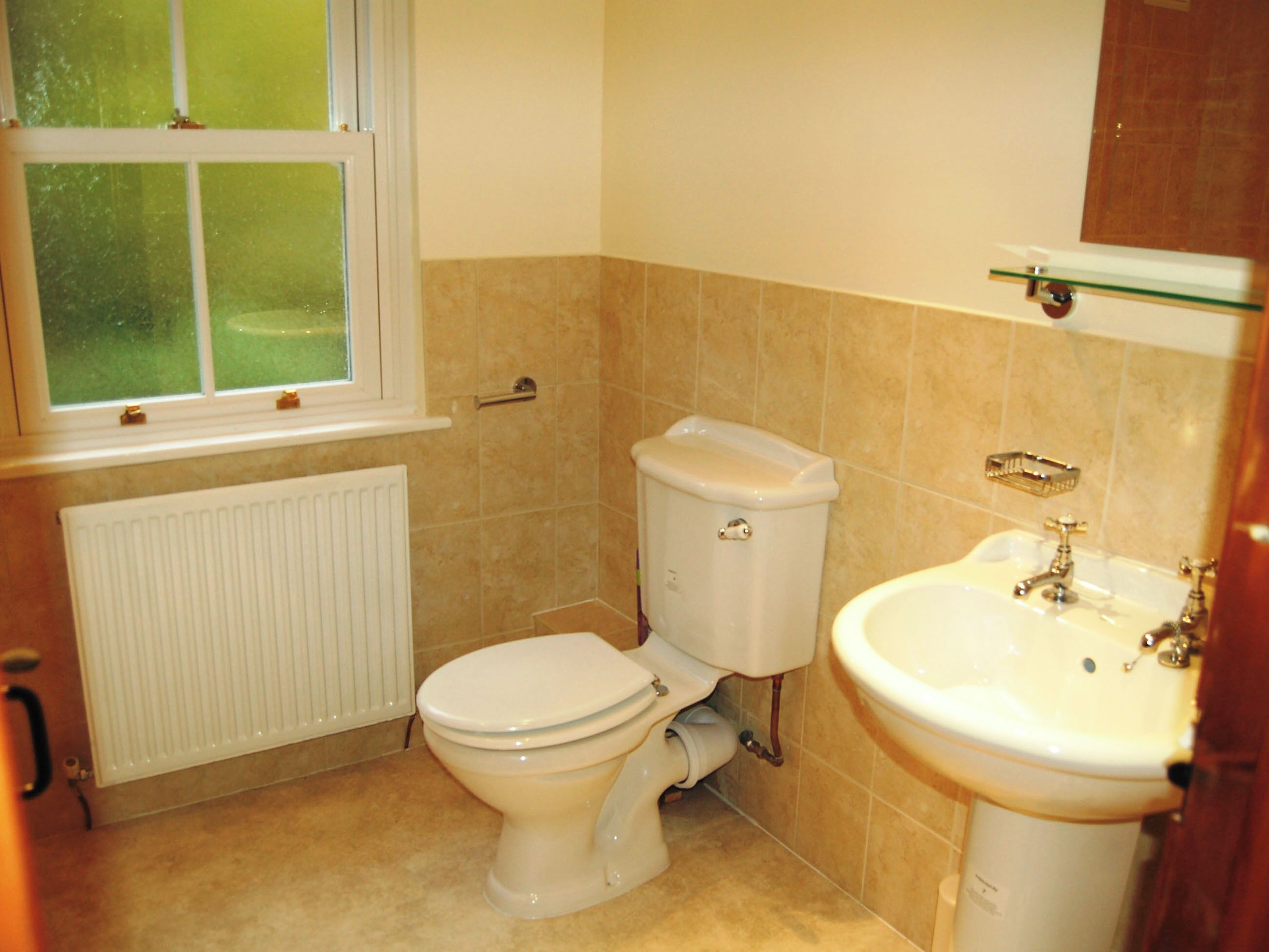 Ein Badezimmer mit Toilette, Waschbecken und Fenster.