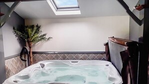 A hot tub in a room with a skylight, a potted plant, and a towel rack. - 3 bedroom accommodation in Arkleby, near Cockermouth (Arkleby, near Cockermouth)