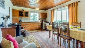 A cozy kitchen with wooden cabinets, a dining area with a table and chairs, and a large window with curtains. - 3 bedroom accommodation in Arkleby, near Cockermouth (Arkleby, near Cockermouth)