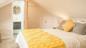 A bedroom with a bed, a bedside table, a lamp, and a door. - 3 bedroom accommodation in Windermere (Windermere)