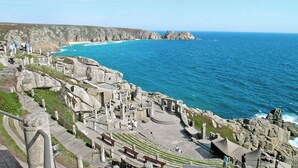 A coastal archaeological site with ruins, steps, and a view of the sea.