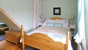 A bedroom with a wooden bed, a nightstand, a dresser, and a small table. - 2 bedroom accommodation in Staithes, near Whitby (Staithes, near Whitby)