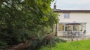 A house with a patio, a small stream, and a garden. - 2 bedroom accommodation in Croasdale, near Ennerdale Lake (Croasdale, near Ennerdale Lake)