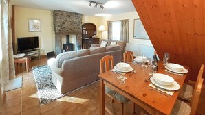 A cozy living room with a sofa, TV, fireplace, and dining table set for four. - 2 bedroom accommodation in Croasdale, near Ennerdale Lake (Croasdale, near Ennerdale Lake)