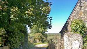 A gravel path leading to a stone building with wooden fences and a wooden gate. There are plaques on the building indicating 'Barn' and 'Cottage'. - 1 bedroom accommodation in Michaelstow, near Camelford (Michaelstow, near Camelford)