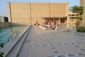 Outdoor pool, pool umbrellas, sun loungers - Hôtel Kaloum (Conakry)