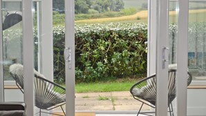 A modern room with a glass door leading to a garden. There are two black chairs with white cushions. - 3 bedroom accommodation in Brancaster Staithe, near Hunstanton (Brancaster Staithe, near Hunstanton)