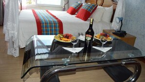 A hotel room with a bed, a glass table with breakfast, and a bottle of Bailey's. - Nice Digital Hotel Mwea (Nairobi)