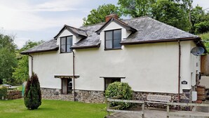 A two-story house with a stone foundation, a white exterior, and a grey roof. - Honeysuckle Cottage - 29938 (Longdown, near Exeter)