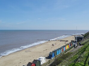 A beach with a row of colorful beach huts and a clear view of the sea. - 5 bedroom accommodation in Mundesley (Mundesley)