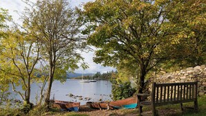 A lakeside view with boats, a stone wall, and a bench. - 2 bedroom accommodation in Bowness-on-Windermere (Bowness-on-Windermere)