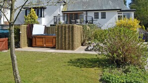 A house with a large garden, a wooden deck, and a white exterior. - 4 bedroom accommodation in Wern-y-Wylan (Wern-y-Wylan)