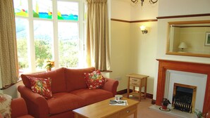 A living room with a sofa, coffee table, and fireplace. - 4 bedroom accommodation in Portinscale, near Keswick (Portinscale, near Keswick)