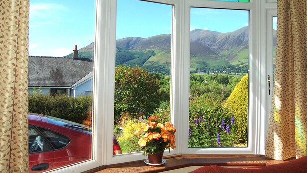 A room with a large window offering a view of a mountainous landscape. - 4 bedroom accommodation in Portinscale, near Keswick (Portinscale, near Keswick)