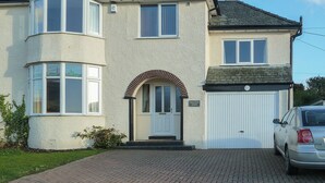 A two-story house with a bay window, a front door with an arch, and a garage. - 4 bedroom accommodation in Portinscale, near Keswick (Portinscale, near Keswick)