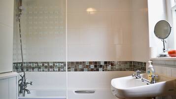 Une salle de bain avec une baignoire, un lavabo et une douche.
