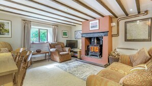 Una sala de estar acogedora con chimenea, asientos cómodos y un ventanal grande.