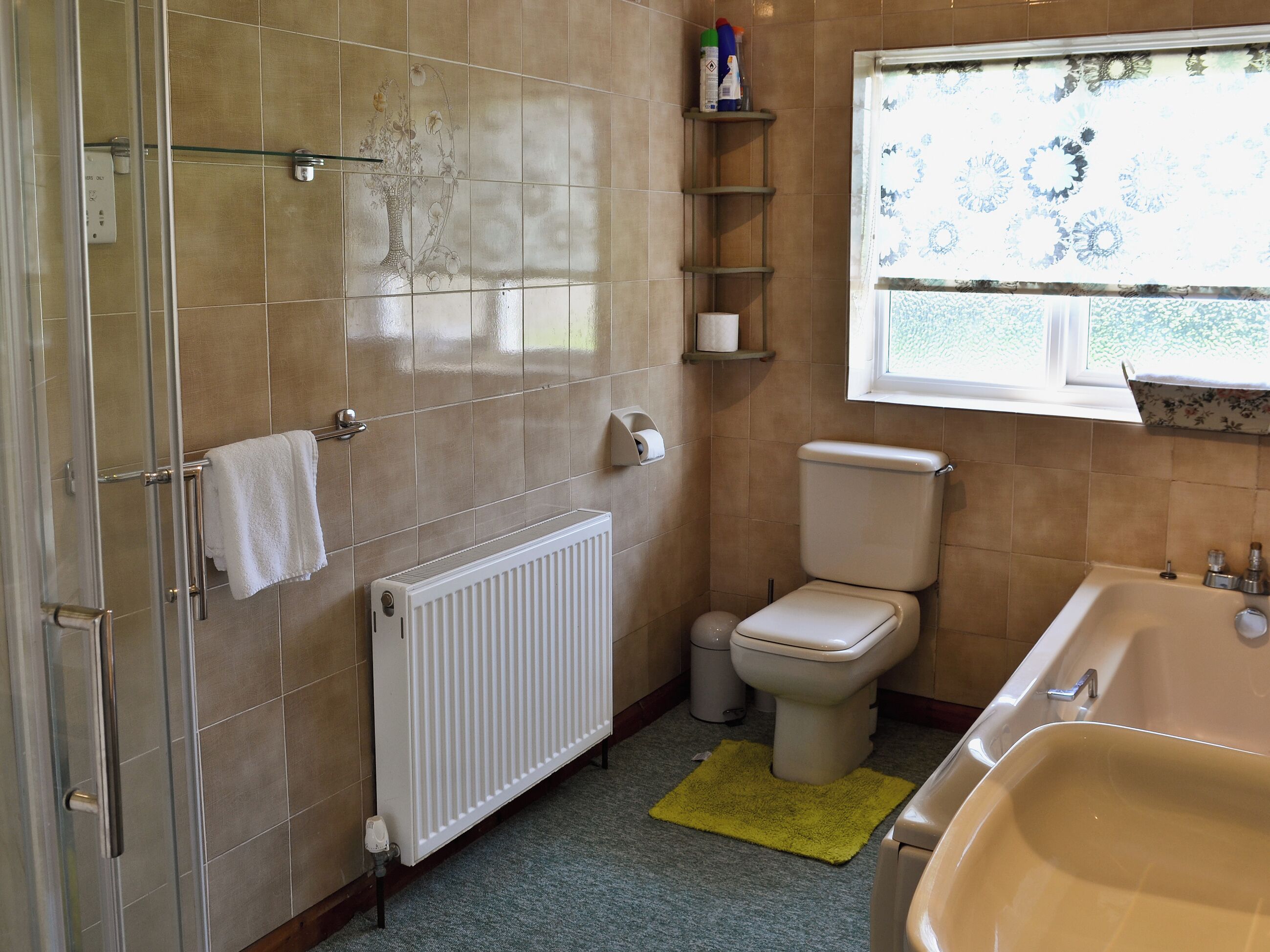 A bathroom with a shower, toilet, and bathtub.