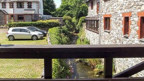 A stone building with a garden and a small stream. - 2 bedroom accommodation in Buckfastleigh (Buckfastleigh)