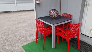 Una mesa con cuatro sillas rojas, una esfera decorativa y un tapete verde.