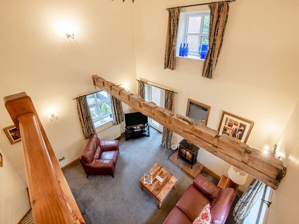 A living room with a wooden staircase, leather sofas, a fireplace, and a television. - 3 bedroom accommodation in York (York)
