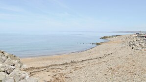A rocky beach with a clear sky and calm sea.